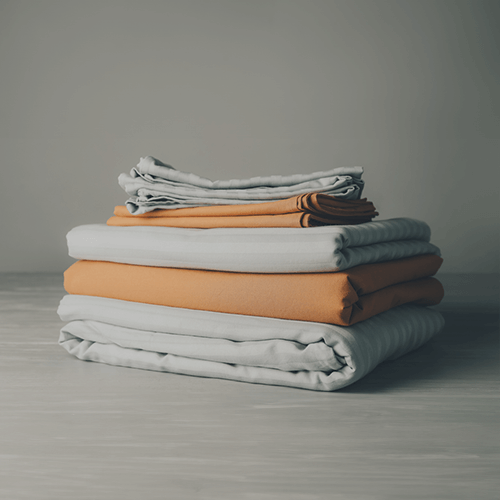 gray and orange sheets folded in a pile