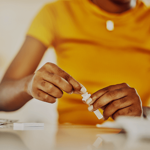 A woman in a yellow shirt does an at-home medical test