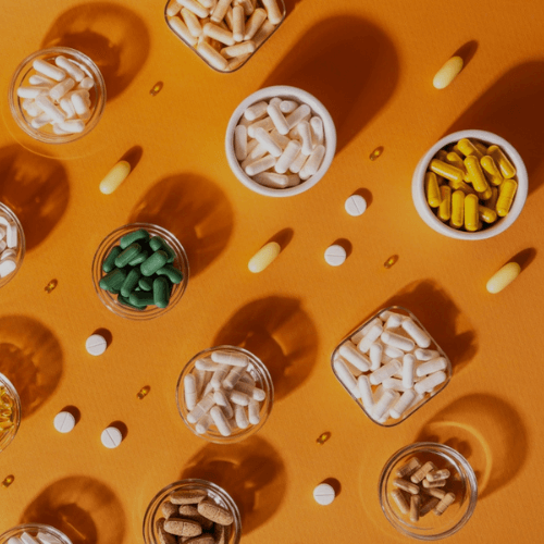 bottles of supplements on an orange background